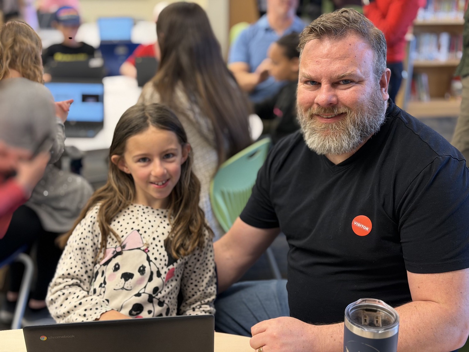Cody Robertson sitting with his daughter in a warm learning setting